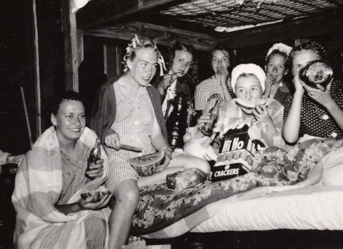 In 1947 these girls are enjoying midnight snacks in their rustic cabin.