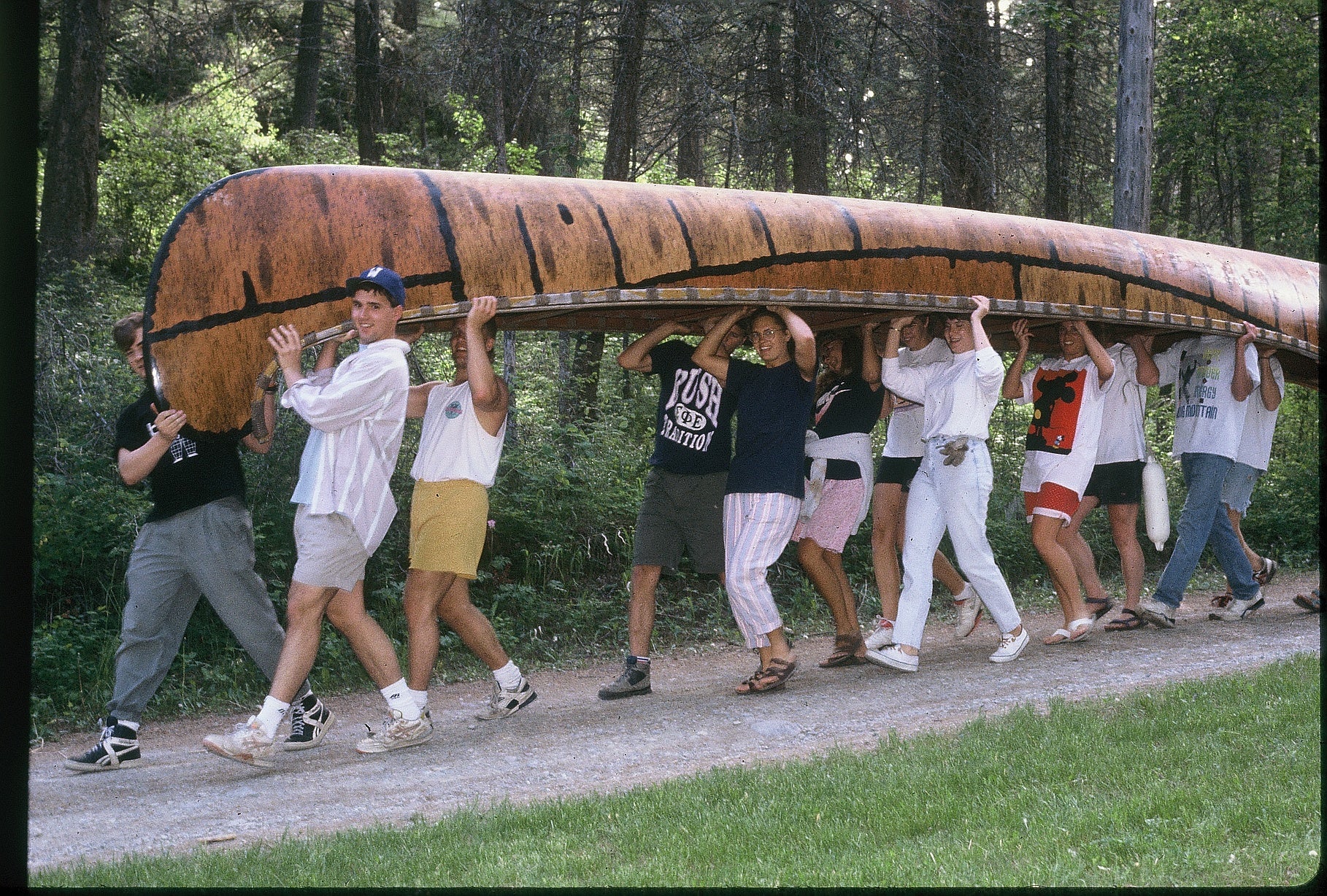 The summer staff enjoy the teamwork of preparing to launch  a 26' Voyager canoe.